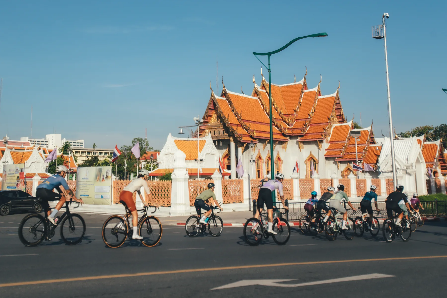 A group of cyclists riding together through the city at sunrise